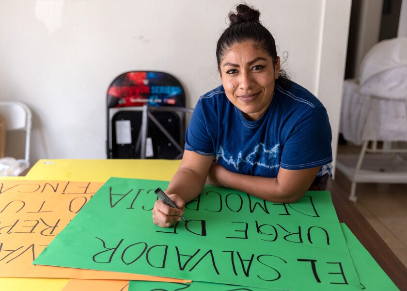 Martha Peinado prepara carteles para la Cumbre de las Americas, en su hogar en Los Ángeles, el domingo 29 de mayo de 2022.